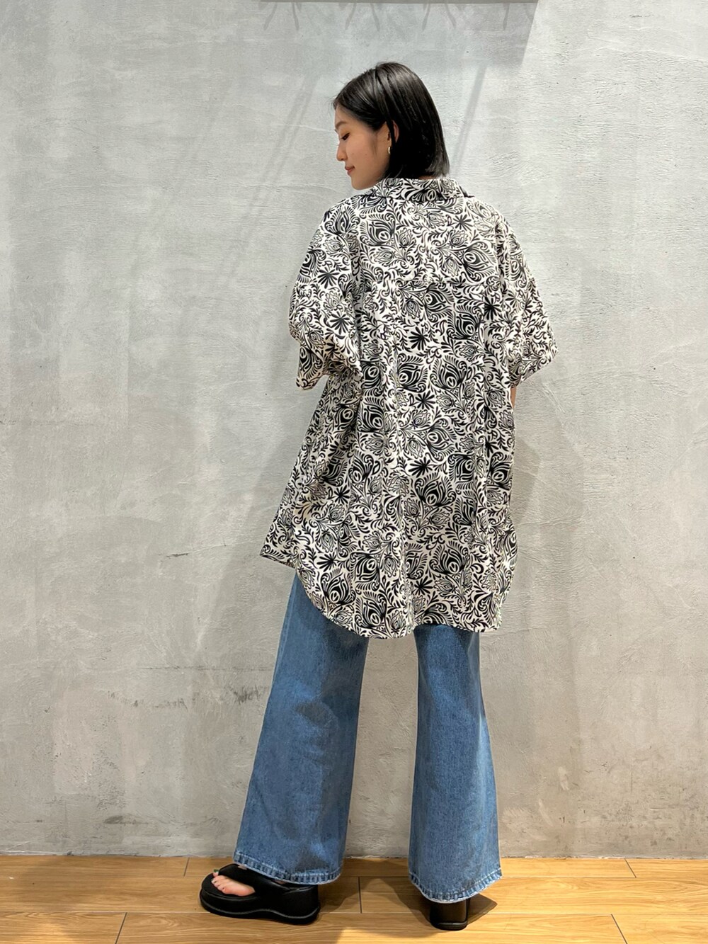 ブラック系のキャミソール、ホワイト系のシャツ/ブラウス、ブルー系のデニムパンツを着用したレディースの夏コーディネートの3枚目の写真