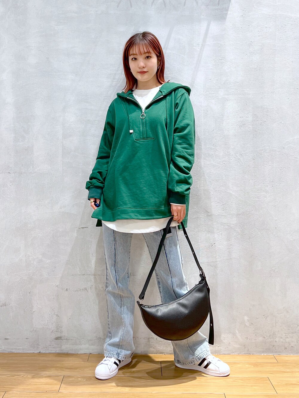 ブルー系のデニムパンツ、グリーン系のスウェット、ホワイト系のTシャツ/カットソーを着用したレディースの冬コーディネートの3枚目の写真