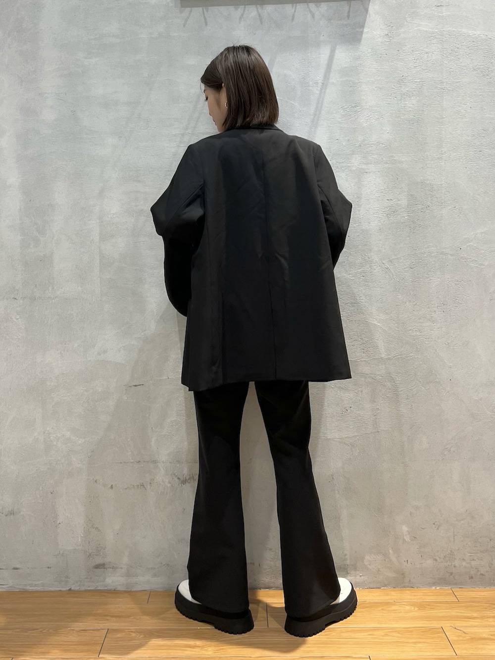 ブラック系のスラックス、ブラック系のテーラードジャケット、グレー系のTシャツ/カットソーを着用したレディースの秋コーディネートの3枚目の写真