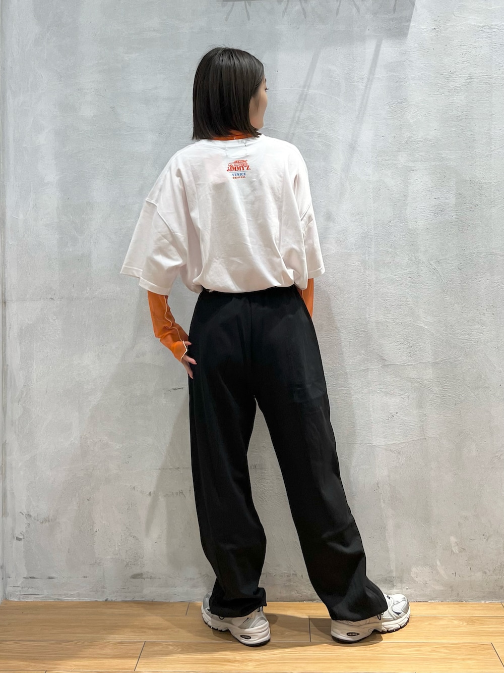 ブラック系のスウェットパンツ、グレー系のスニーカー、ホワイト系のTシャツ/カットソーを着用したレディースの夏コーディネートの3枚目の写真