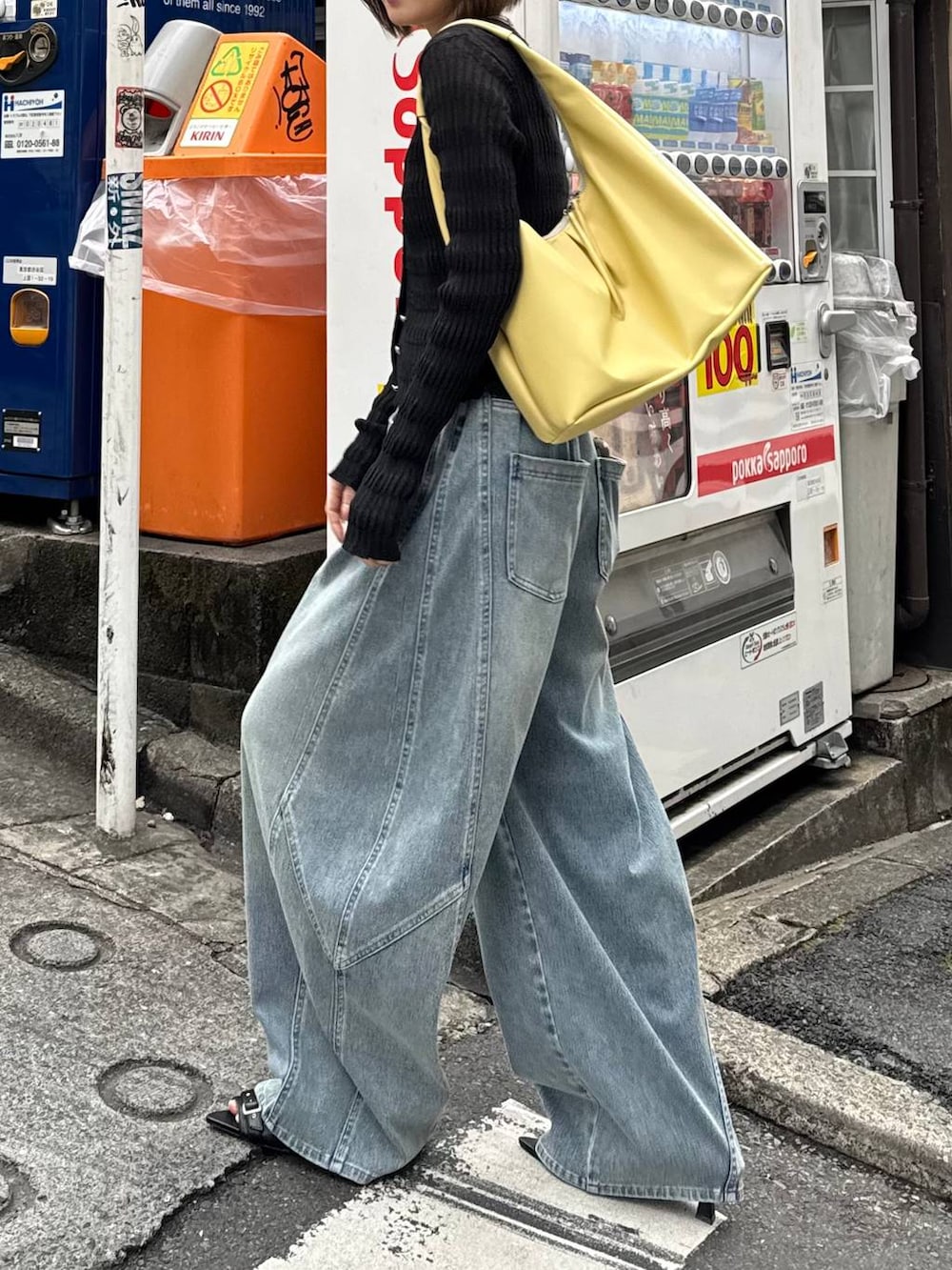 イエロー系のトートバッグ、ブルー系のデニムパンツ、ブラック系のカーディガン/ボレロを着用したレディースの春コーディネートの7枚目の写真