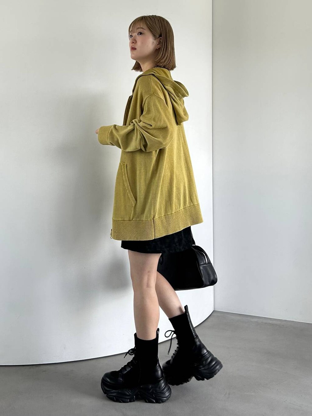 ブラック系のブーツ、ホワイト系のTシャツ/カットソー、イエロー系のパーカーを着用したレディースの夏コーディネートの3枚目の写真