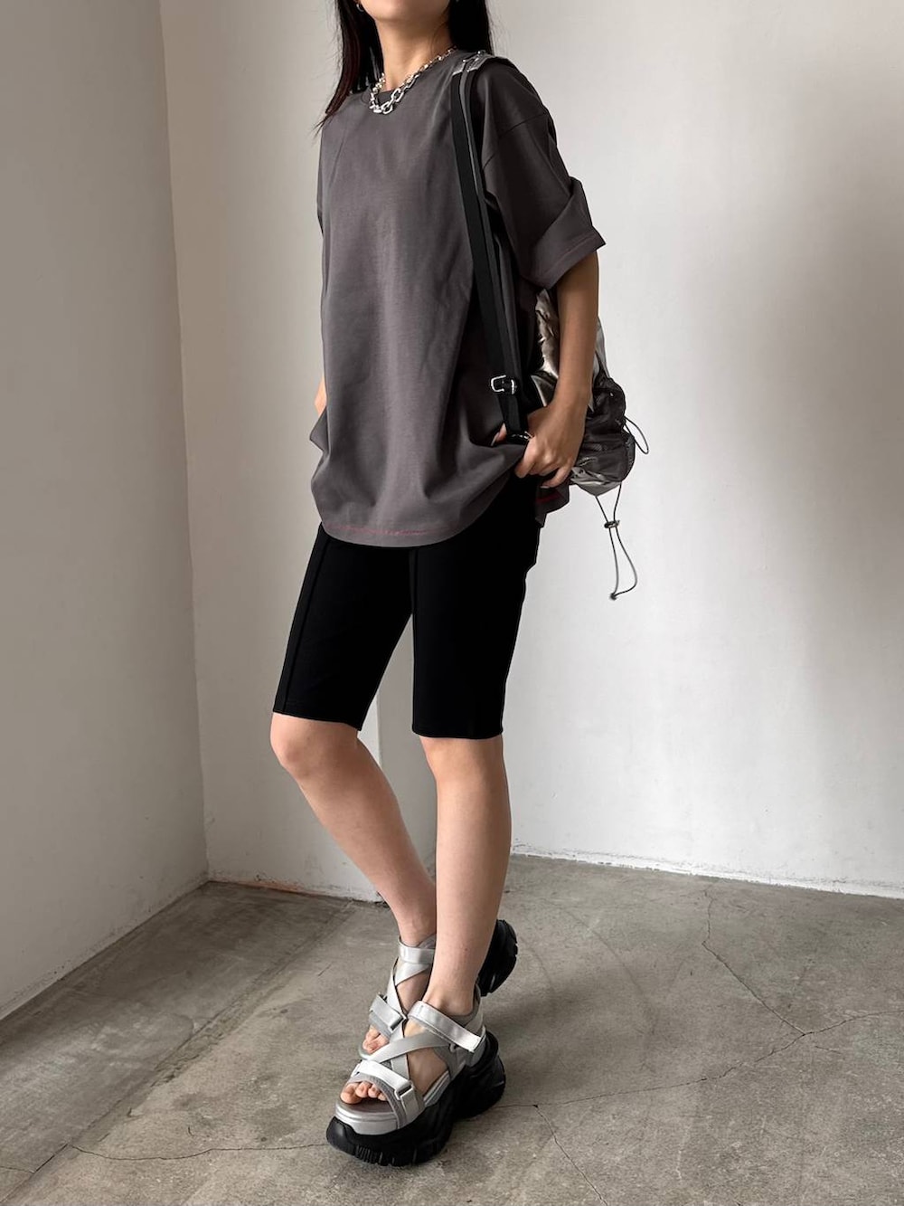 グレー系のサンダル、シルバー系のバックパック/リュック、グレー系のTシャツ/カットソーを着用したレディースの春コーディネートの3枚目の写真