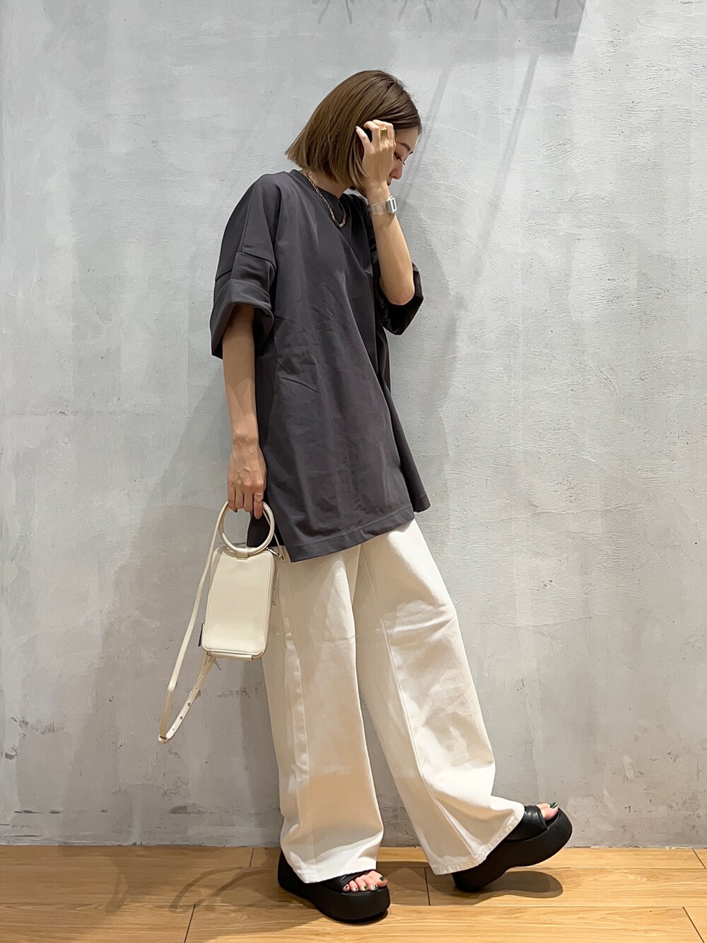 グレー系のTシャツ/カットソー、ホワイト系のデニムパンツ、ホワイト系のショルダーバッグを着用したレディースの夏コーディネートの2枚目の写真