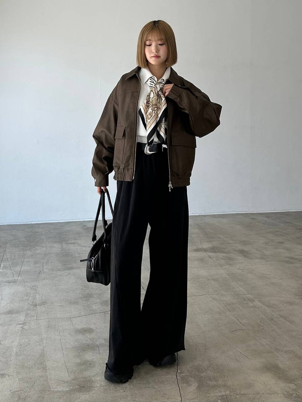 ブラック系のブーツ、ブラック系のスウェットパンツ、ブラック系のボストンバッグを着用したレディースの秋コーディネートの4枚目の写真