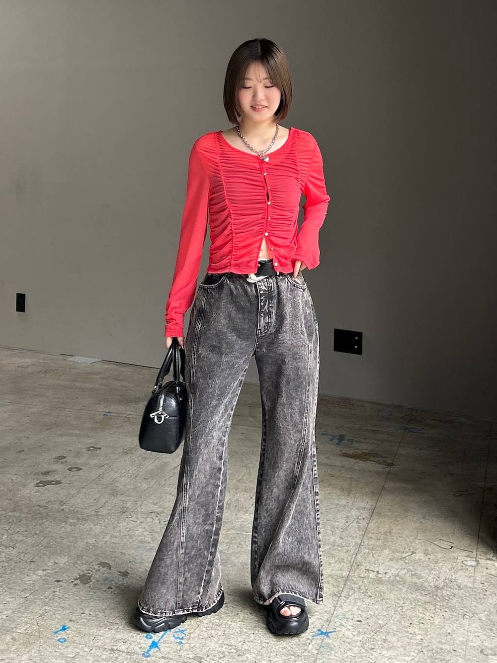 ブラック系のキャミソール、ブラック系のデニムパンツ、ブラック系のボストンバッグを着用したレディースの春コーディネートの6枚目の写真