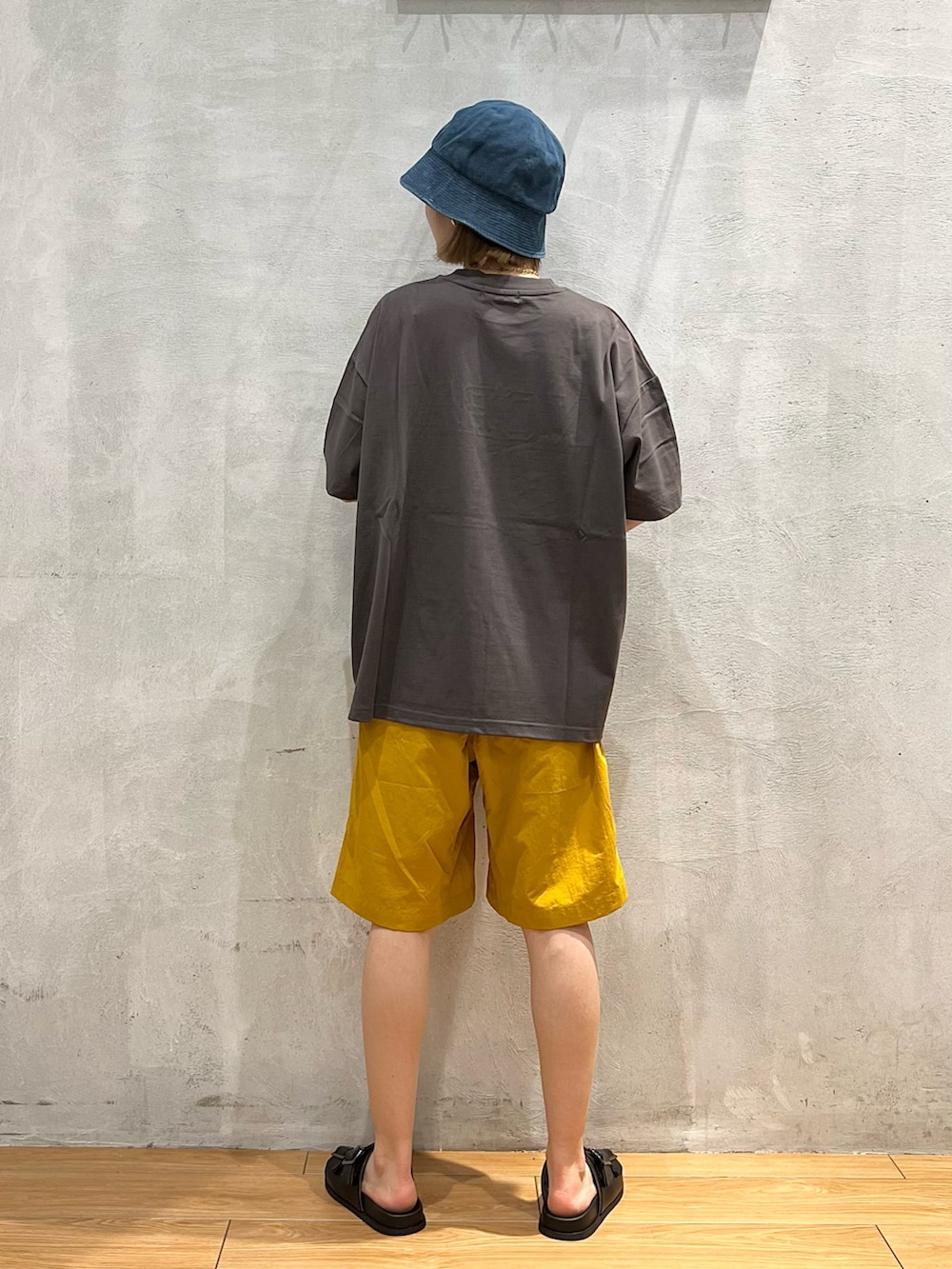 ブラック系のサンダル、イエロー系のその他パンツ、グレー系のTシャツ/カットソーを着用したレディースの夏コーディネートの3枚目の写真