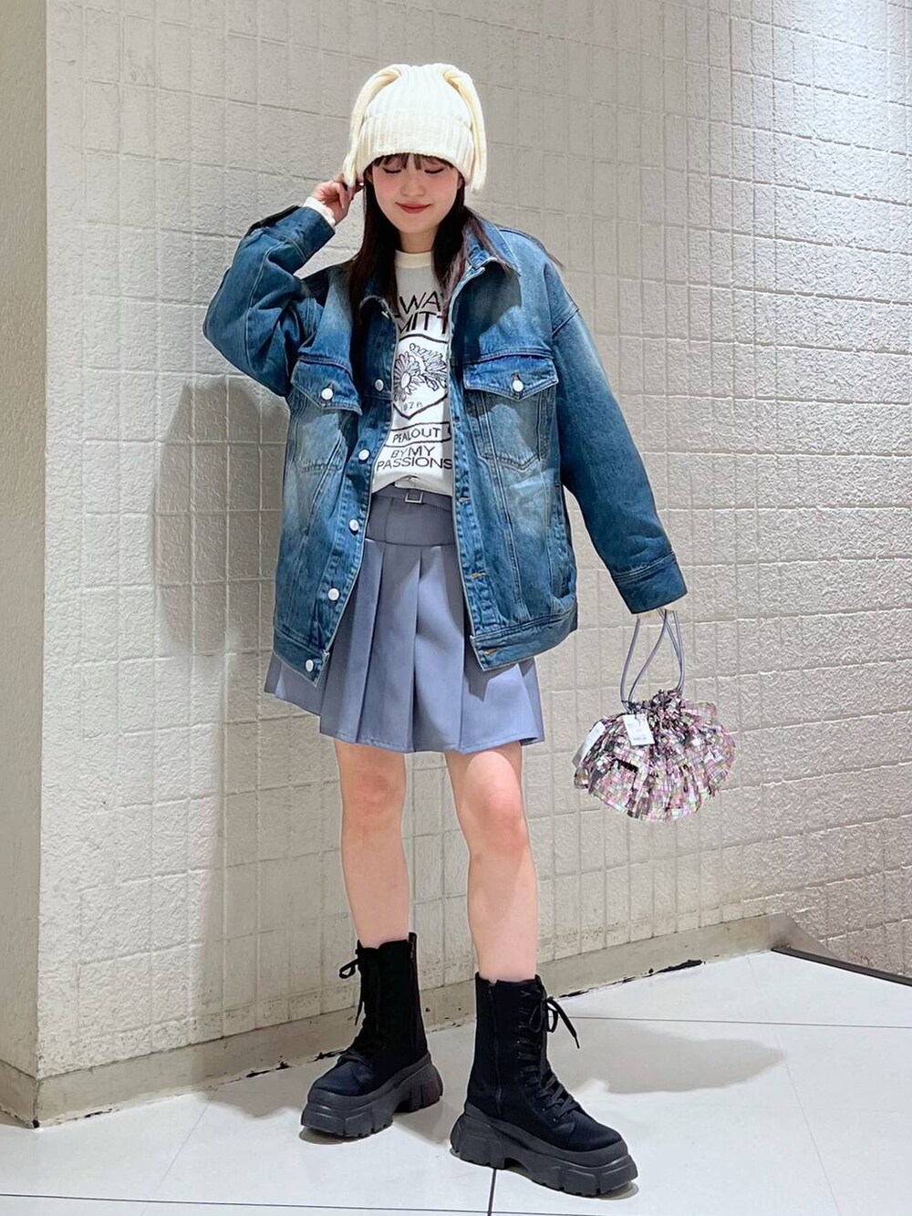 ホワイト系のニット/セーター、ブルー系のデニムジャケット、ブラック系のブーツを着用したレディースの冬コーディネートの6枚目の写真