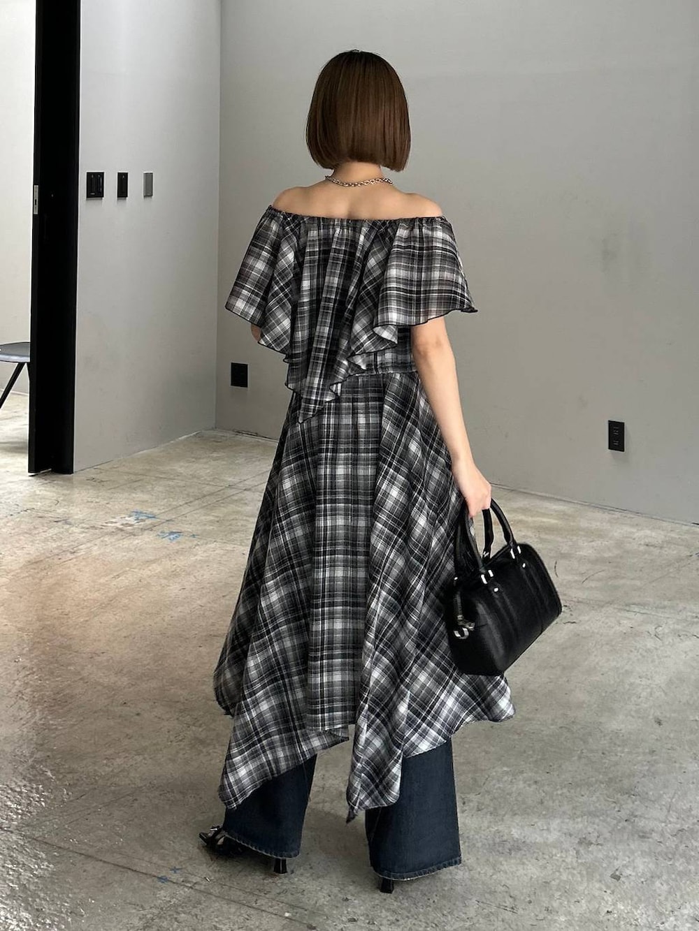 ブルー系のデニムパンツ、ブラック系のボストンバッグ、ブラック系のサンダルを着用したレディースの春コーディネートの3枚目の写真