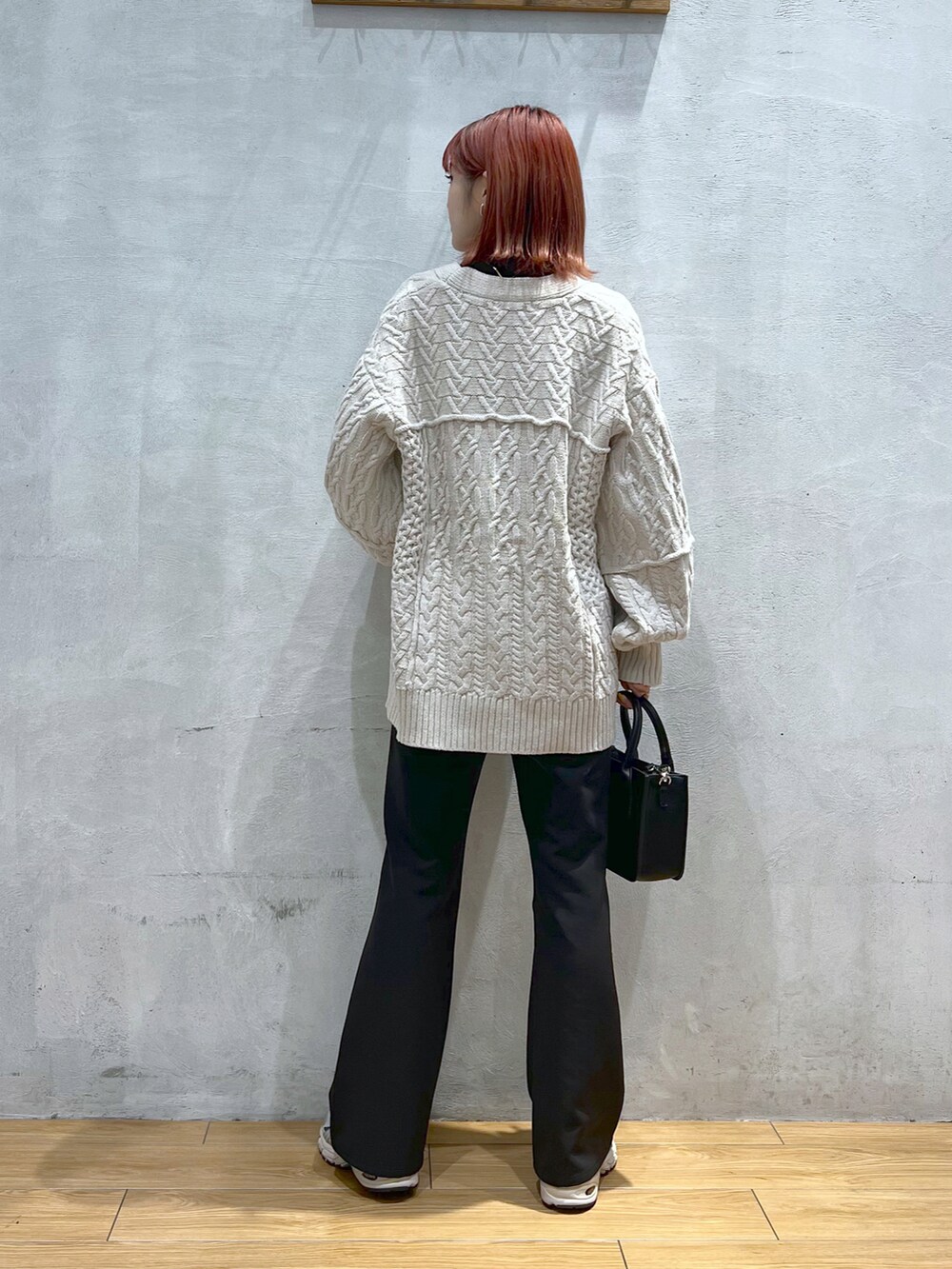 ブラック系のスラックス、ホワイト系のカーディガン/ボレロ、ブラック系のショルダーバッグを着用したレディースの秋コーディネートの3枚目の写真