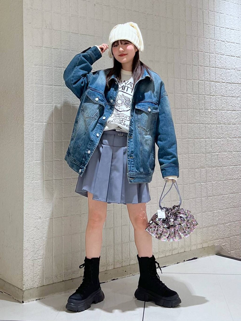 ホワイト系のニット/セーター、ブルー系のデニムジャケット、ブラック系のブーツを着用したレディースの冬コーディネートの2枚目の写真