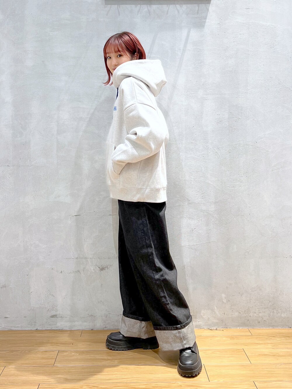 ブラック系のデニムパンツ、グレー系のパーカー、ブラック系のブーツを着用したレディースの冬コーディネートの2枚目の写真