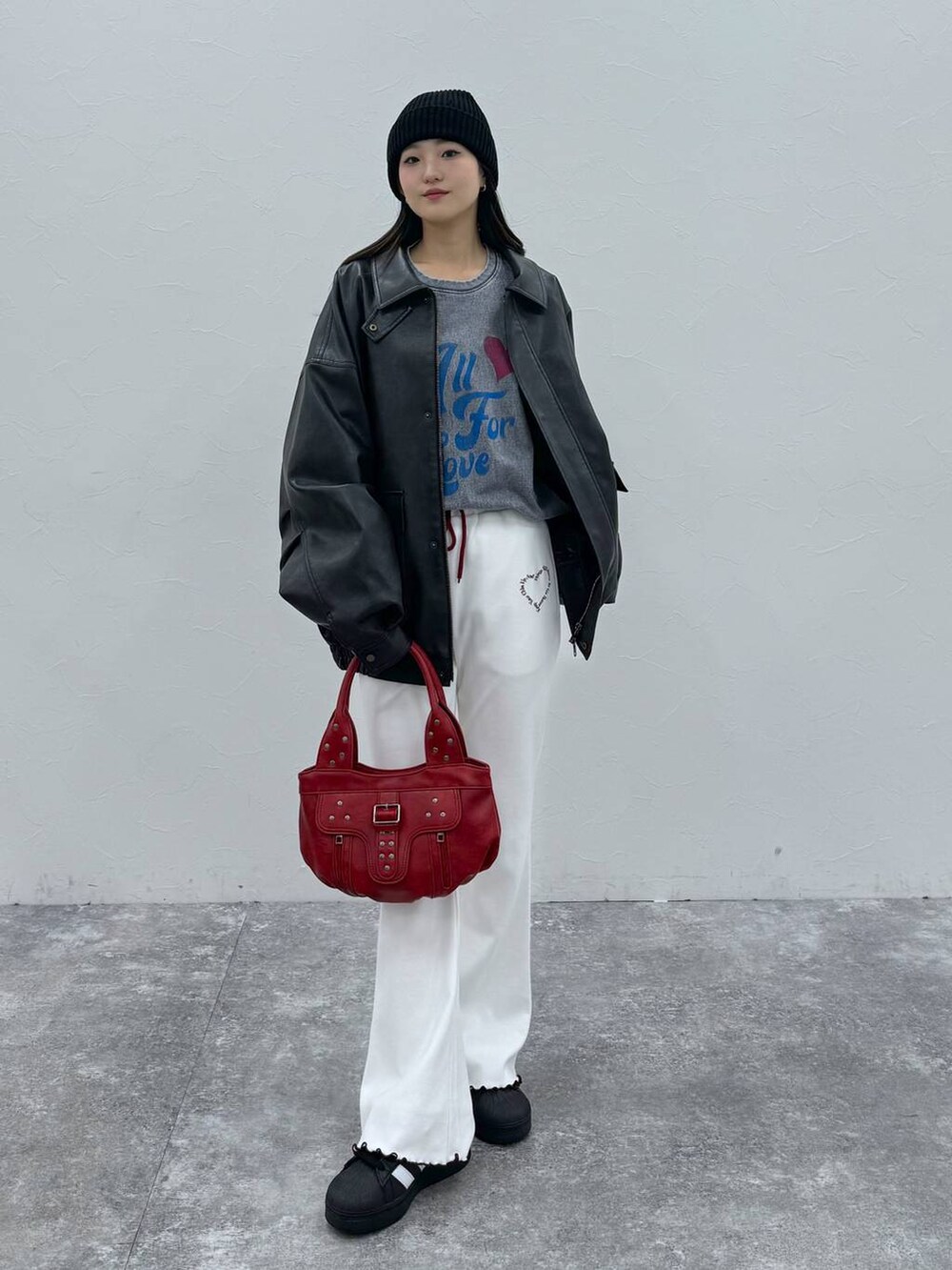 ブラック系のブルゾン、レッド系のハンドバッグ、ベージュ系のその他パンツを着用したレディースの冬コーディネートの3枚目の写真