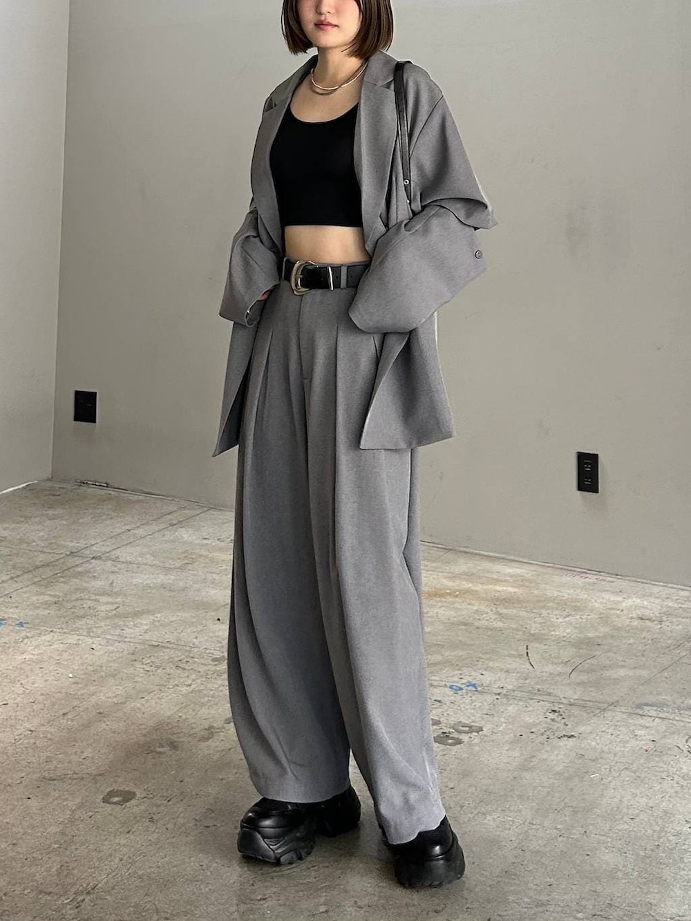 ブラック系のブーツ、ブラック系のキャミソール、ブラック系のハンドバッグを着用したレディースの春コーディネートの5枚目の写真