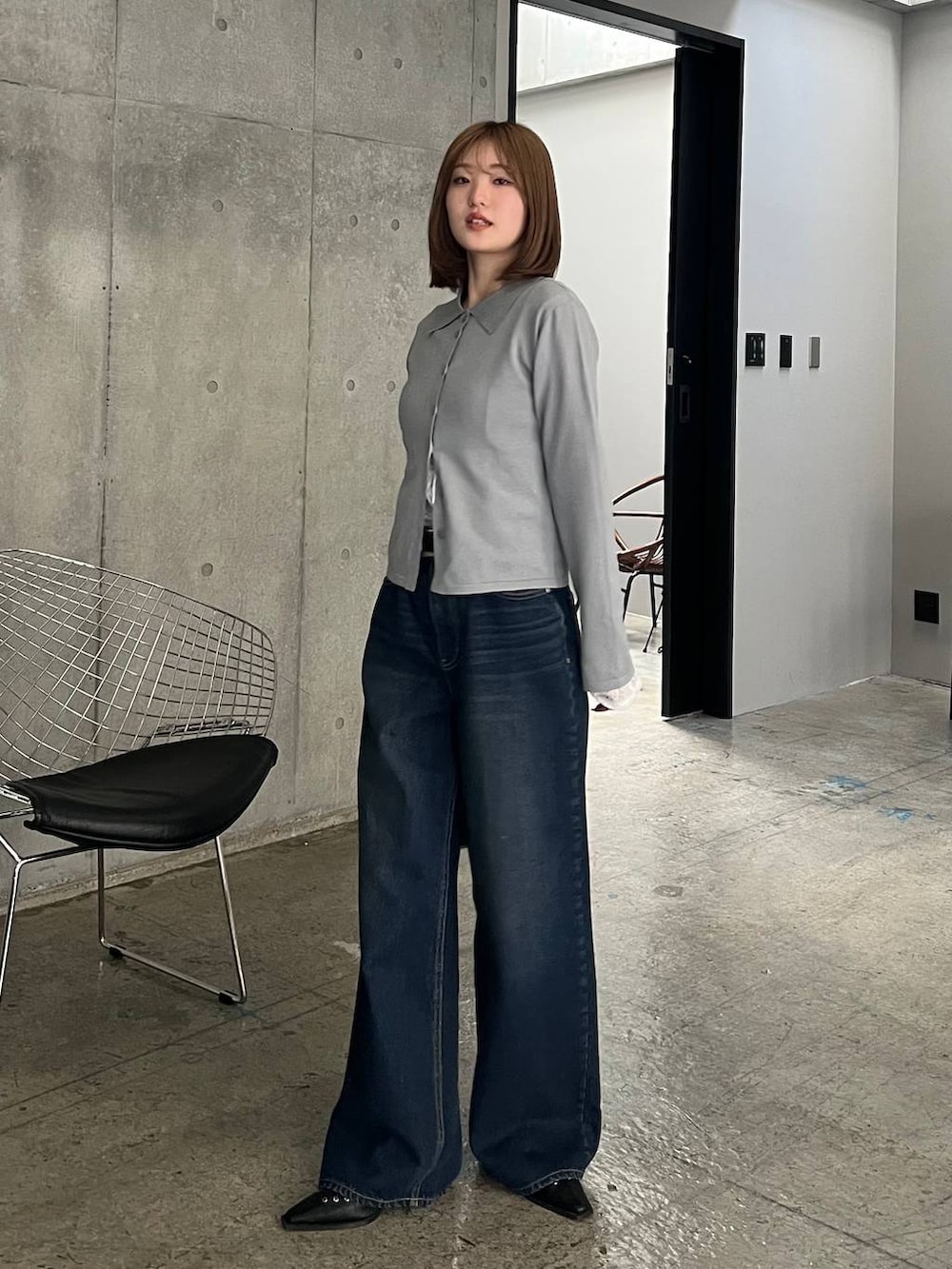 ブルー系のスラックス、ブラック系のボストンバッグ、ブラック系のサンダルを着用したレディースの冬コーディネートの2枚目の写真