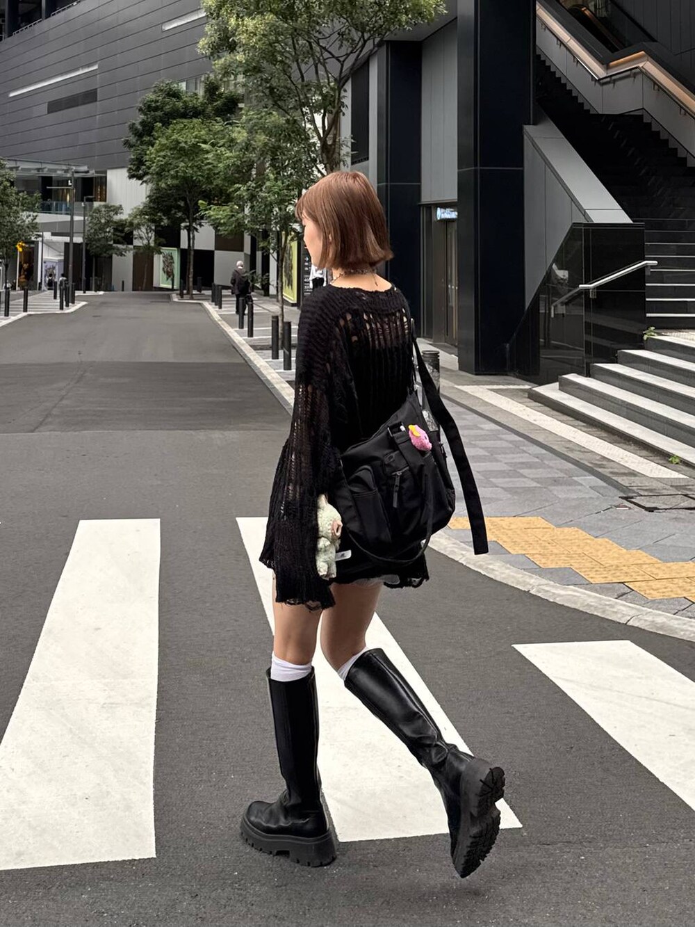 ブラック系のボストンバッグ、ブラック系のニット/セーター、ブラック系のブーツを着用したレディースの秋コーディネートの5枚目の写真