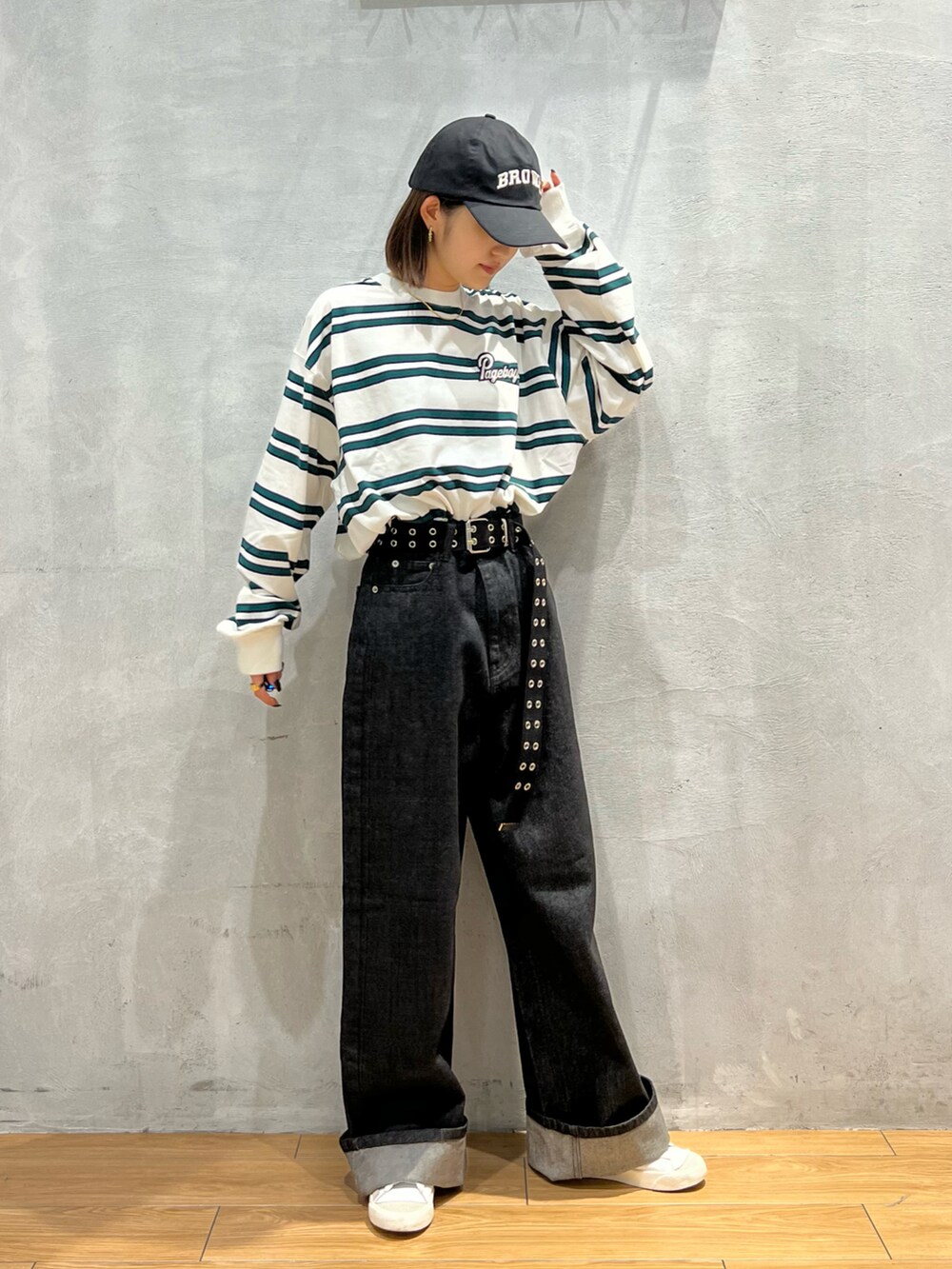 ブラック系のデニムパンツ、ホワイト系のTシャツ/カットソー、ホワイト系のスニーカーを着用したレディースの秋コーディネートの2枚目の写真