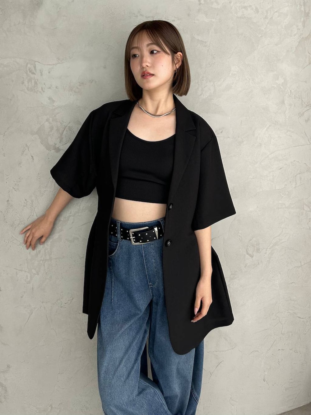 ブラック系のキャミソール、ブルー系のデニムパンツ、ブラック系のサンダルを着用したレディースの春コーディネートの5枚目の写真