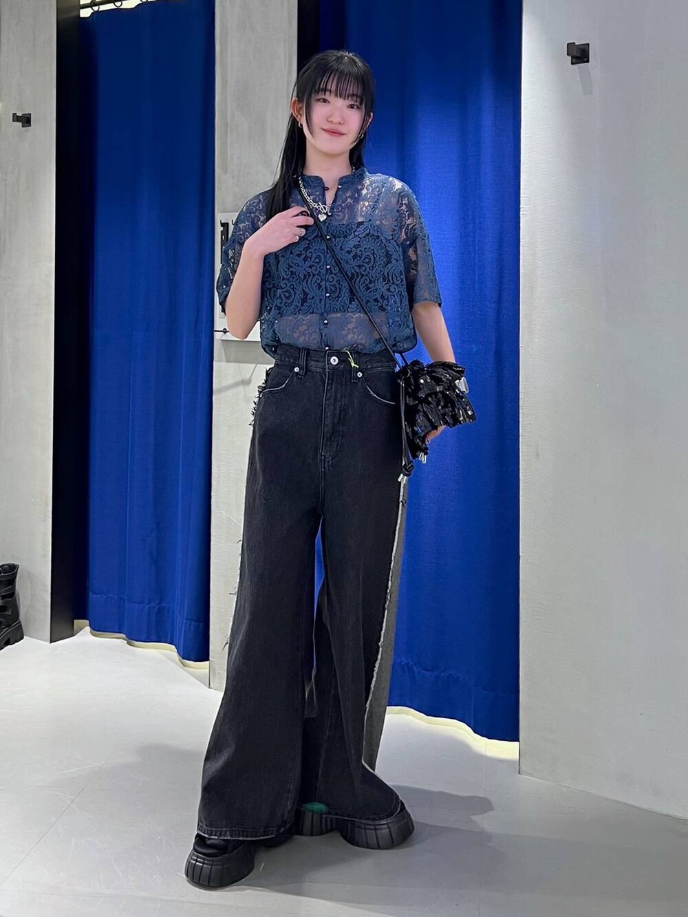 ブラック系のスニーカー、ブルー系のシャツ/ブラウス、ブラック系のキャミソールを着用したレディースの春コーディネートの2枚目の写真