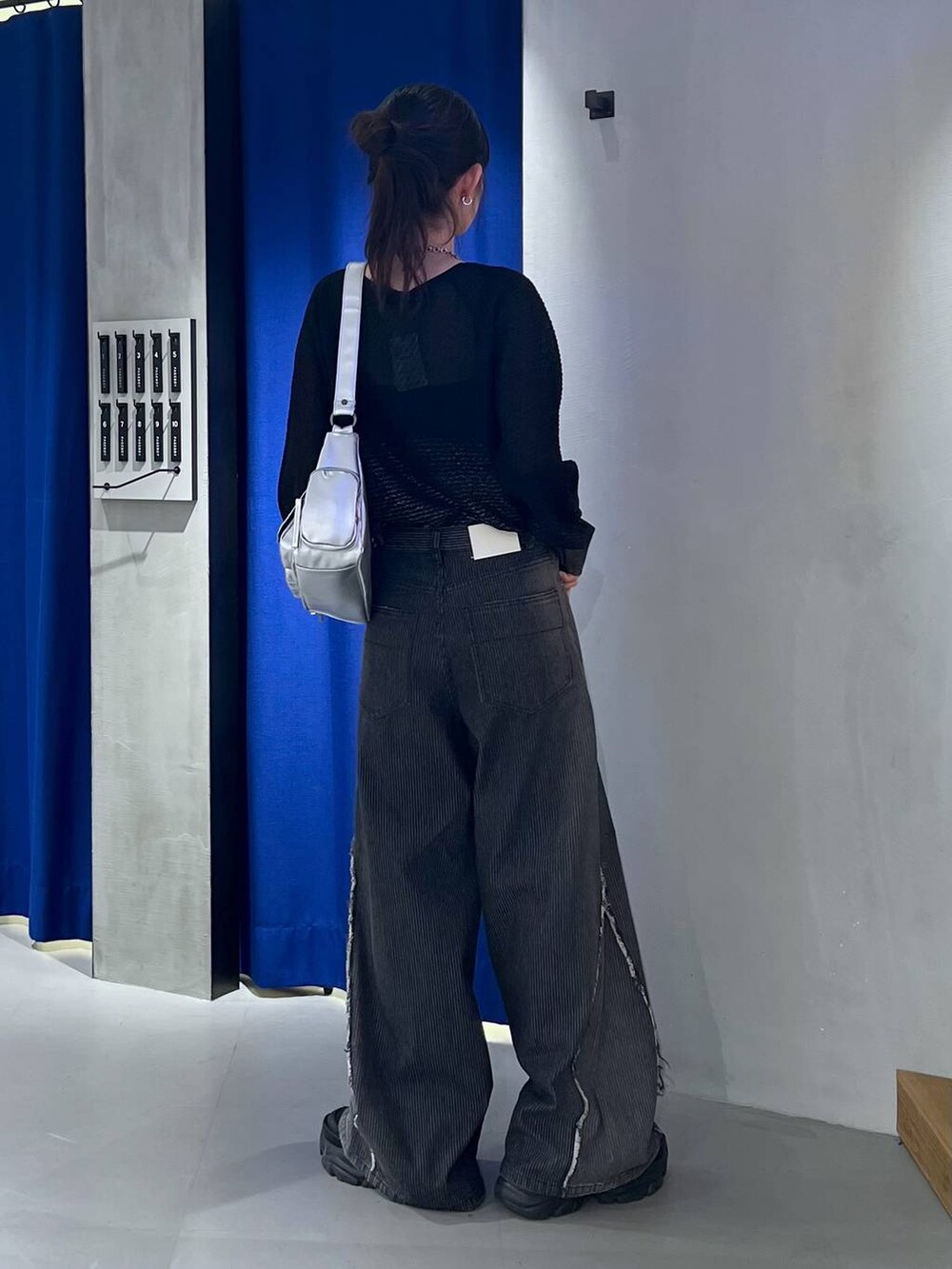 ブラック系のスニーカー、ブラック系のカーディガン/ボレロ、ブラック系のデニムパンツを着用したレディースの秋コーディネートの4枚目の写真