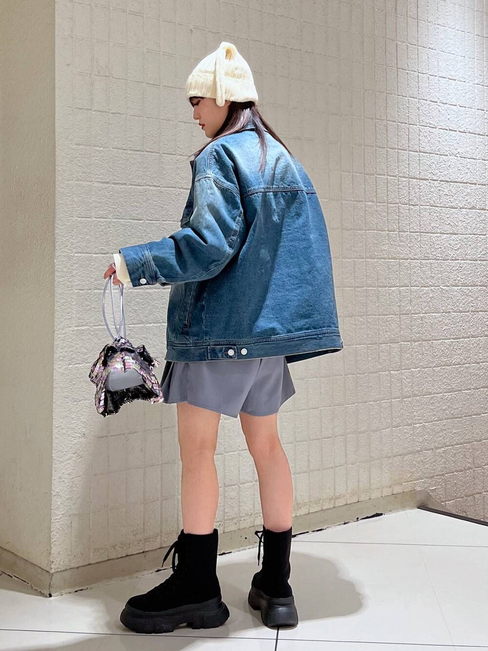 ホワイト系のニット/セーター、ブルー系のデニムジャケット、ブラック系のブーツを着用したレディースの冬コーディネートの4枚目の写真