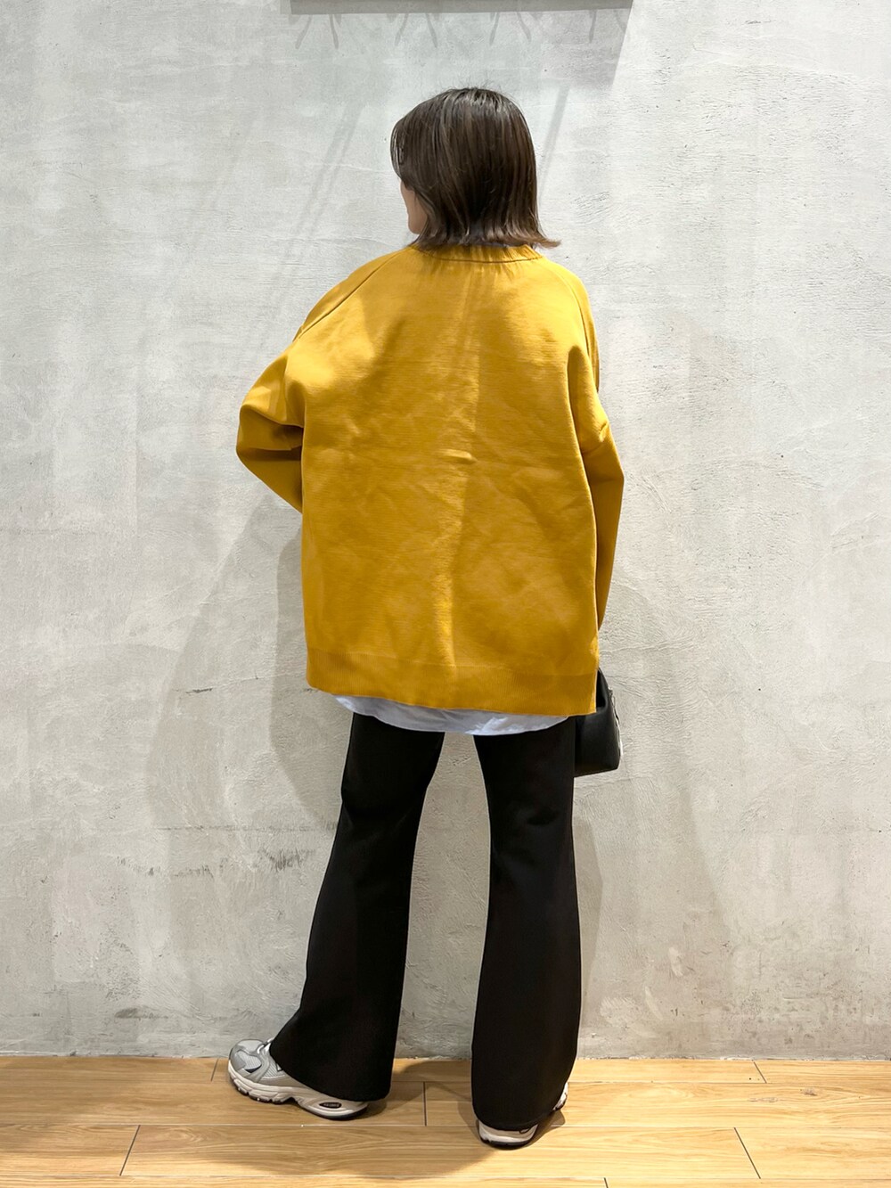 ブラック系のスラックス、ブラック系のショルダーバッグ、グレー系のスニーカーを着用したレディースの秋コーディネートの4枚目の写真