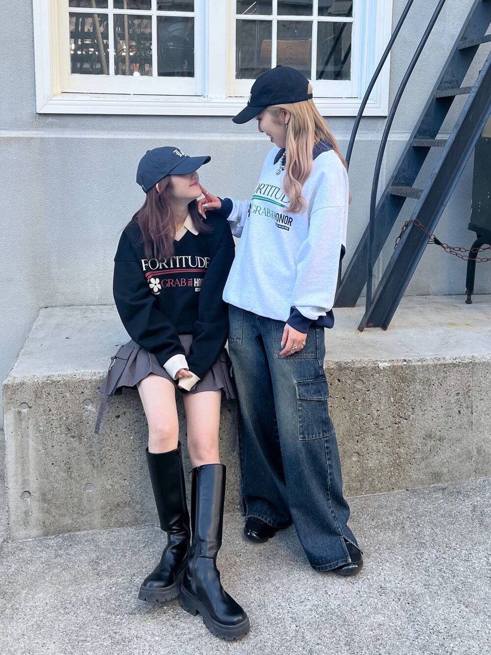 ブラック系のブーツ、グレー系のスカート、ブラック系のスウェットを着用したレディースの冬コーディネートの2枚目の写真