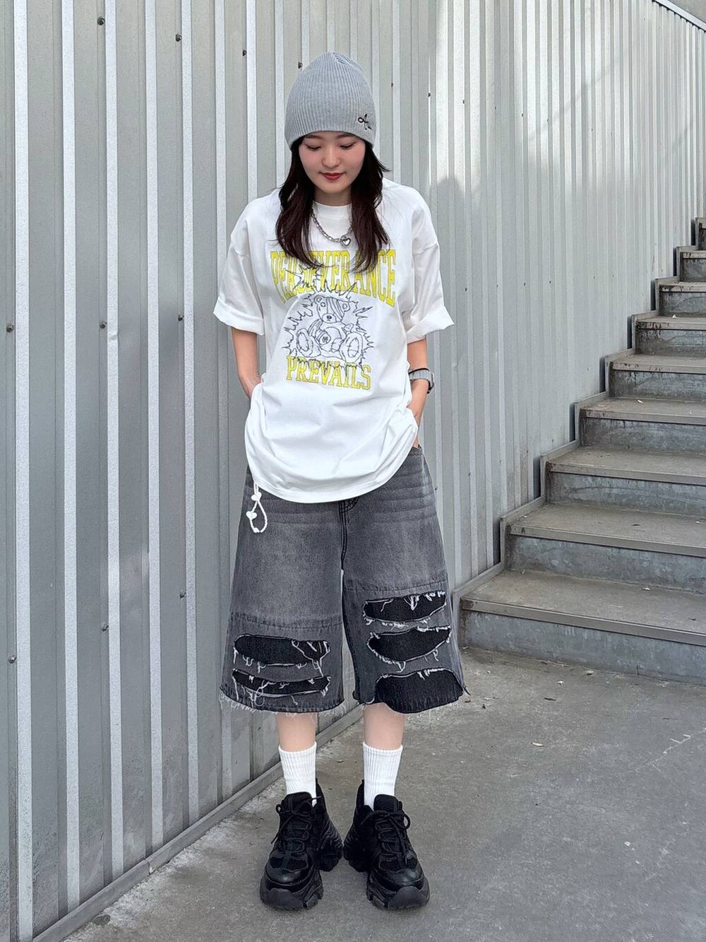 ブラック系のスニーカー、ブラック系のデニムパンツ、ホワイト系のTシャツ/カットソーを着用したレディースの春コーディネートの2枚目の写真