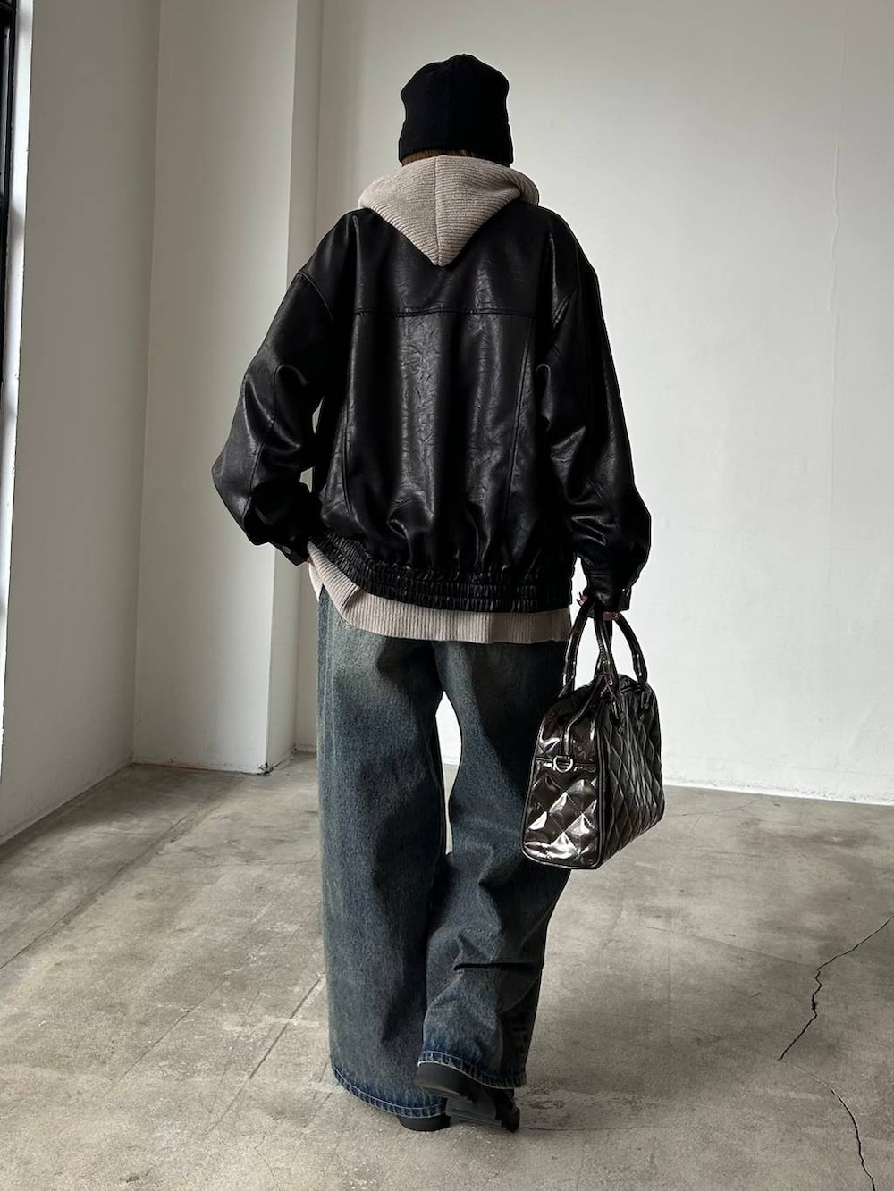 ブルー系のデニムパンツ、ブラック系のブルゾン、ブラック系のブーツを着用したレディースの冬コーディネートの3枚目の写真