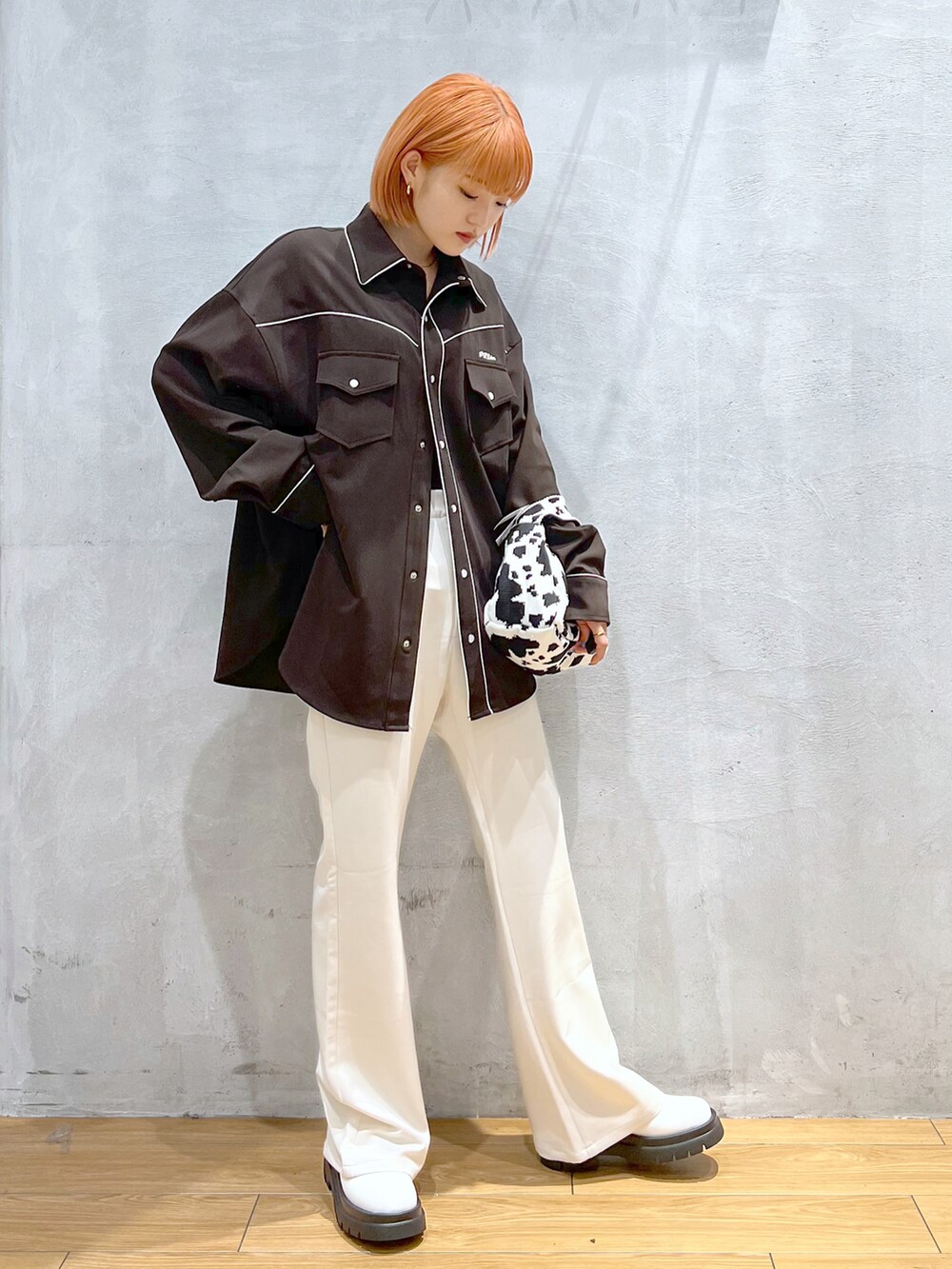 ホワイト系のスラックス、ホワイト系のブーツ、ブラウン系のシャツ/ブラウスを着用したレディースの秋コーディネートの2枚目の写真