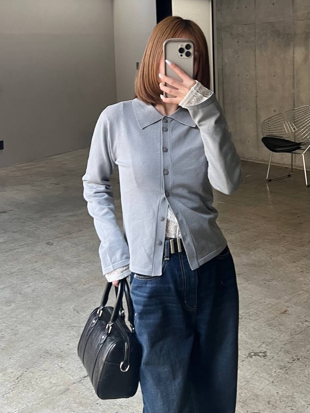 ブルー系のスラックス、ブラック系のボストンバッグ、ブラック系のサンダルを着用したレディースの冬コーディネートの5枚目の写真