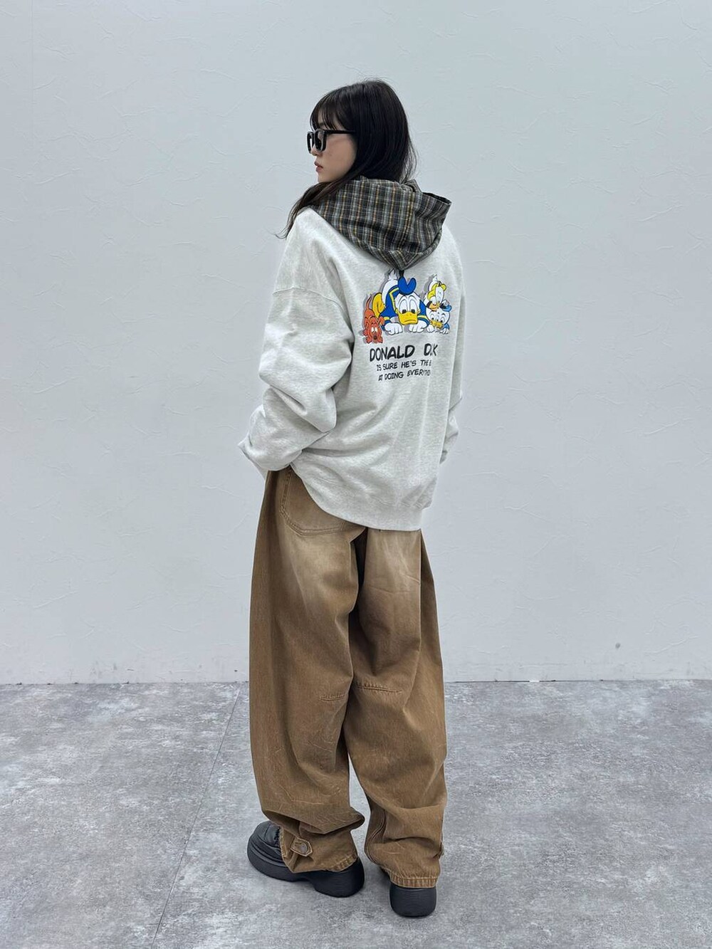 ブラック系のスリッポン、ベージュ系のデニムパンツ、グレー系のスウェットを着用したレディースの冬コーディネートの3枚目の写真