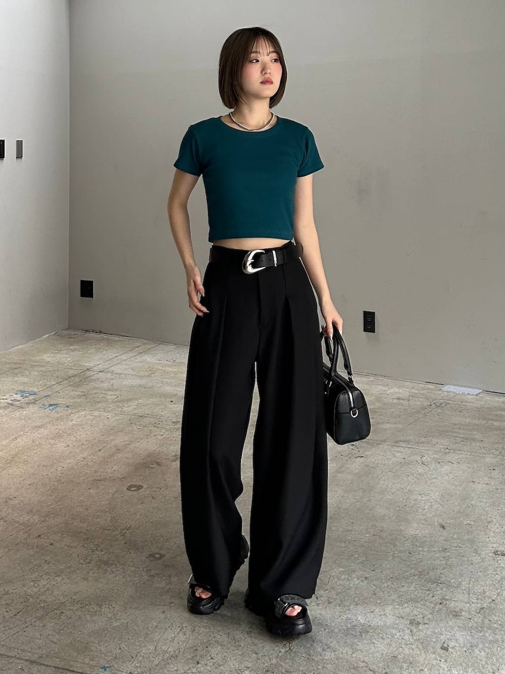 ブラック系のボストンバッグ、ブラック系のサンダル、ブラック系のスラックスを着用したレディースの春コーディネートの5枚目の写真