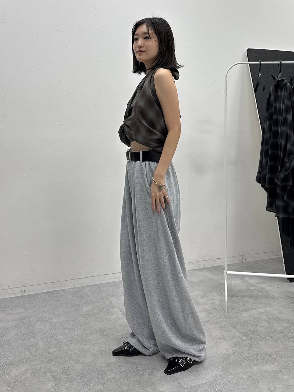 ブラウン系のシャツ/ブラウス、グレー系のスウェットパンツ、ブラック系のベルトを着用したレディースの夏コーディネートの2枚目の写真
