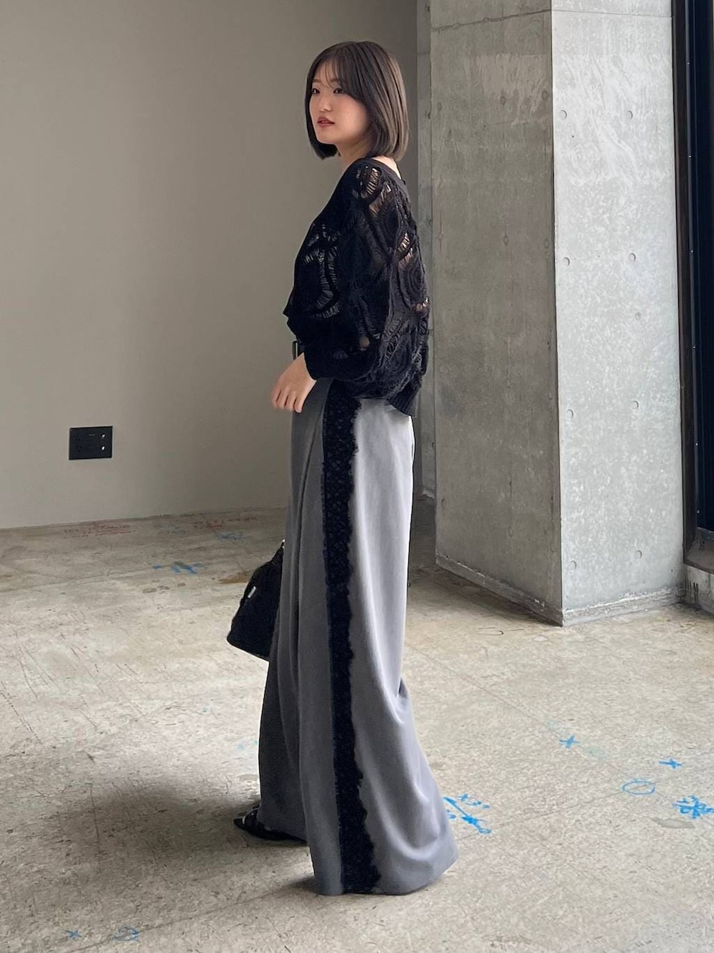 ホワイト系のキャミソール、ブラック系のカーディガン/ボレロ、ブラック系のサンダルを着用したレディースの春コーディネートの2枚目の写真