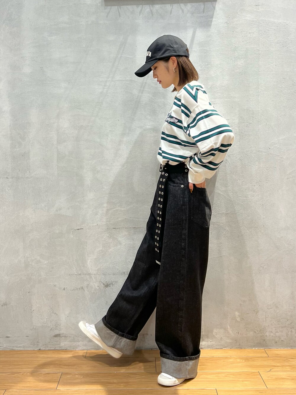 ブラック系のデニムパンツ、ホワイト系のTシャツ/カットソー、ホワイト系のスニーカーを着用したレディースの秋コーディネートの3枚目の写真