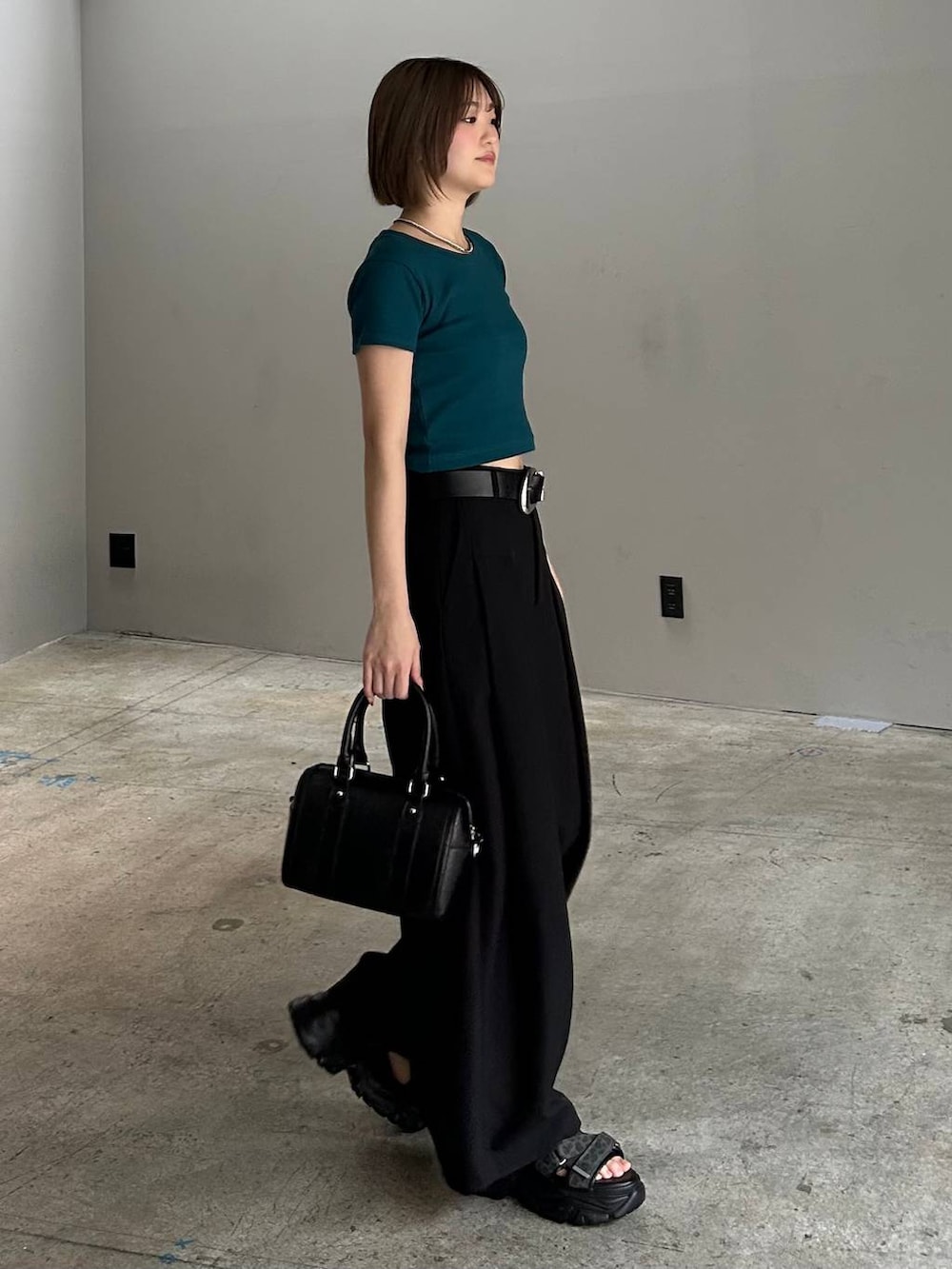 ブラック系のボストンバッグ、ブラック系のサンダル、ブラック系のスラックスを着用したレディースの春コーディネートの6枚目の写真