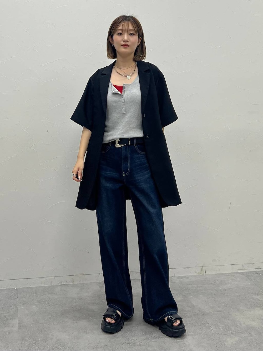 レッド系のキャミソール、ブルー系のデニムパンツ、グレー系のタンクトップを着用したレディースの夏コーディネートの4枚目の写真
