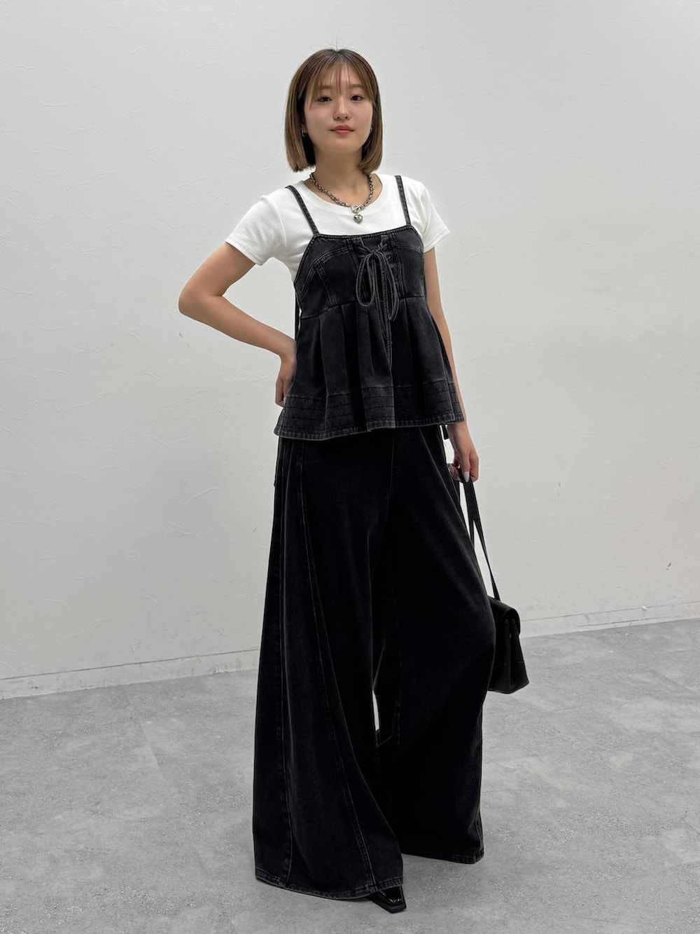 ブラック系のデニムパンツ、ブラック系のその他トップス、ホワイト系のTシャツ/カットソーを着用したレディースの夏コーディネートの5枚目の写真