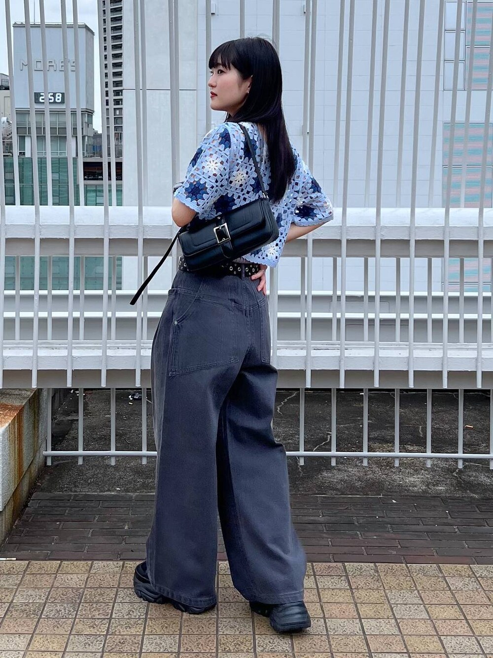 グレー系のタンクトップ、ブラック系のスニーカー、ブラック系のハンドバッグを着用したレディースの夏コーディネートの4枚目の写真