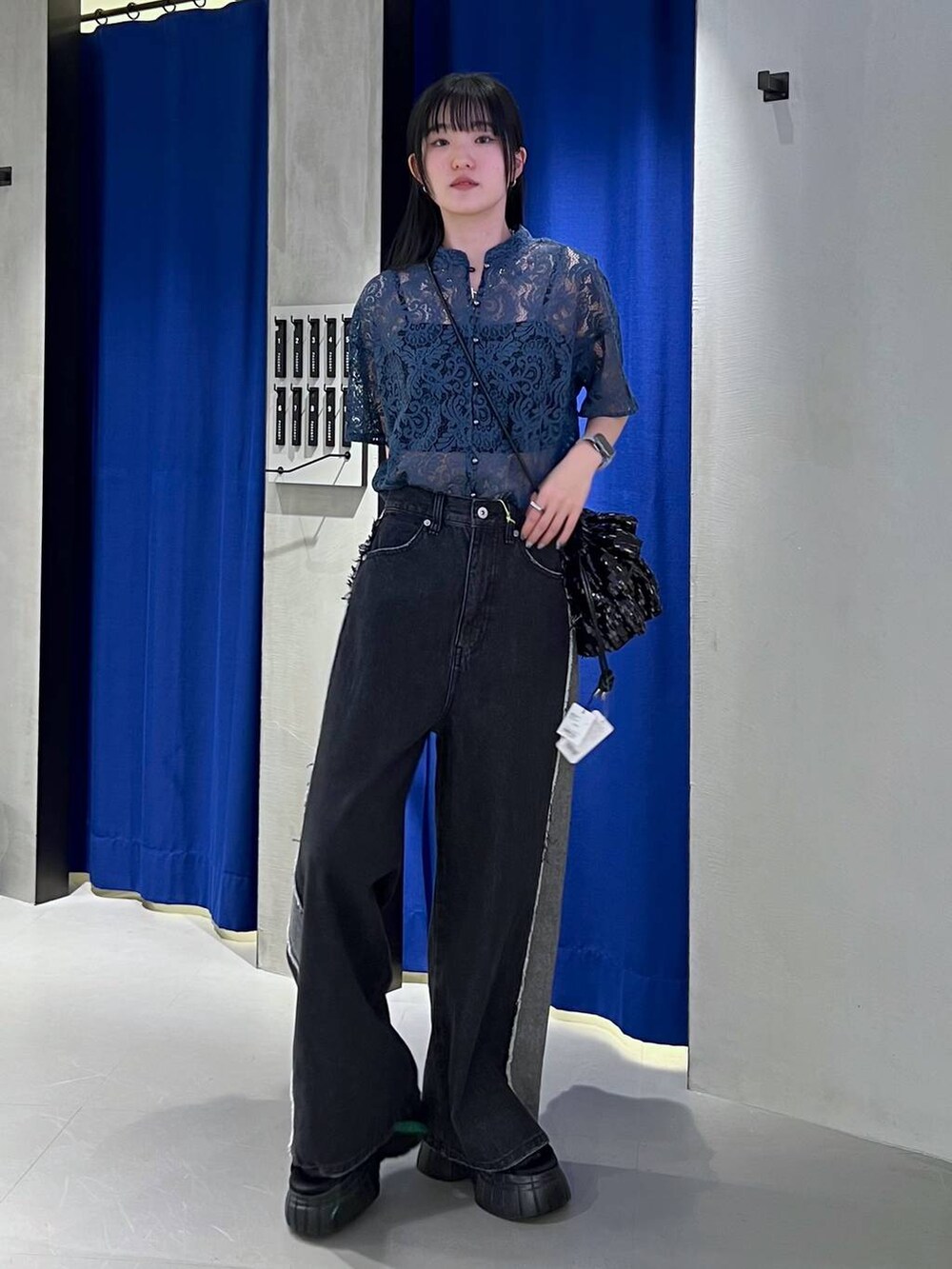 ブラック系のスニーカー、ブルー系のシャツ/ブラウス、ブラック系のキャミソールを着用したレディースの春コーディネートの5枚目の写真