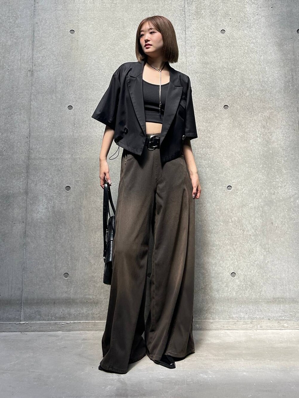 ブラック系のデニムパンツ、ブラック系のキャミソール、ブラック系のショルダーバッグを着用したレディースの夏コーディネートの4枚目の写真