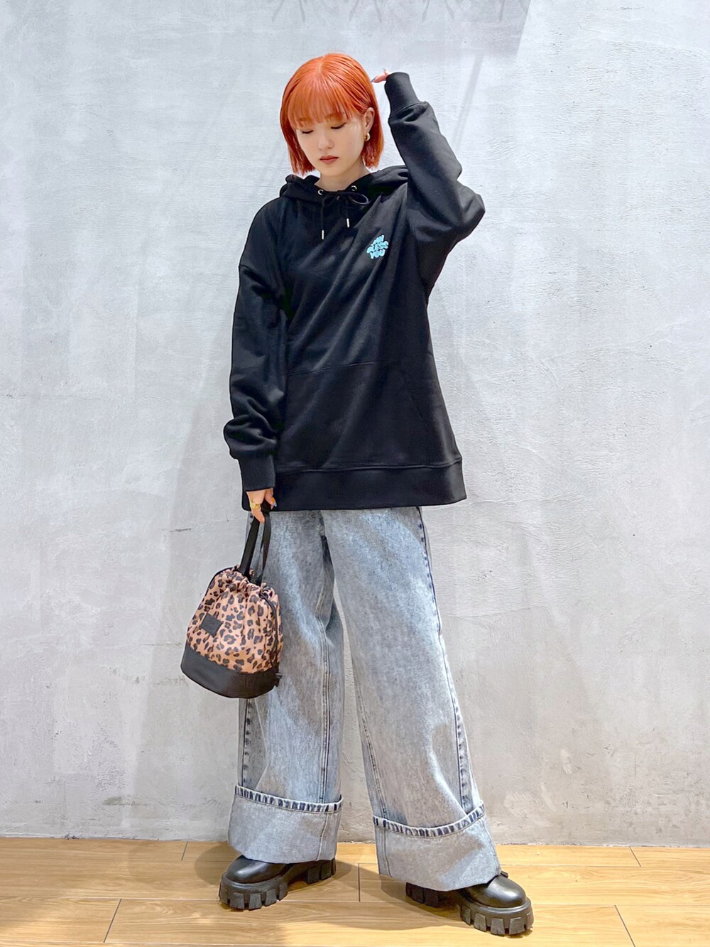 ブルー系のデニムパンツ、ブラック系のブーツ、ブラック系のパーカーを着用したレディースの秋コーディネートの2枚目の写真