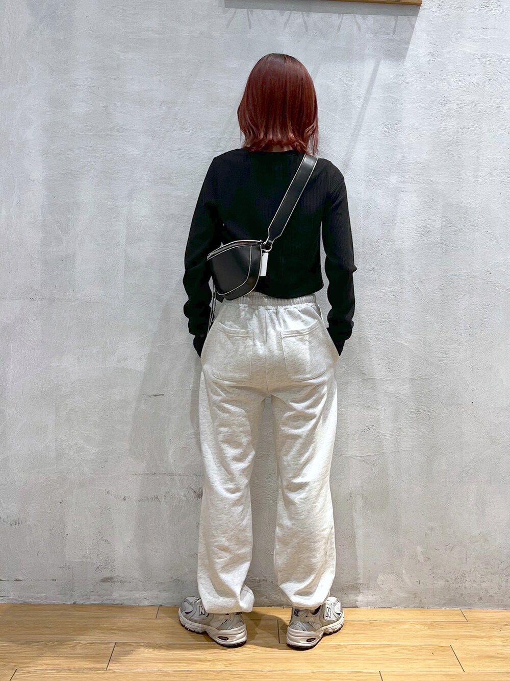 ホワイト系のスニーカー、グレー系のスウェットパンツ、ブラック系のTシャツ/カットソーを着用したレディースの冬コーディネートの2枚目の写真