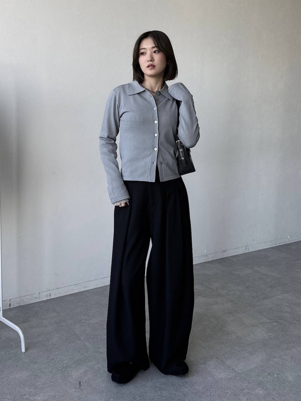 ブラック系のハンドバッグ、ブラック系のスラックス、ブラック系のモカシン/デッキシューズを着用したレディースの冬コーディネートの2枚目の写真