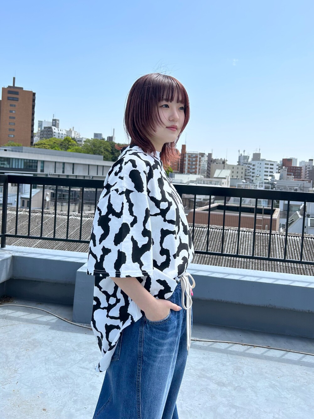 ブルー系のデニムパンツ、ホワイト系のTシャツ/カットソー、イエロー系のショルダーバッグを着用したレディースの春コーディネートの4枚目の写真