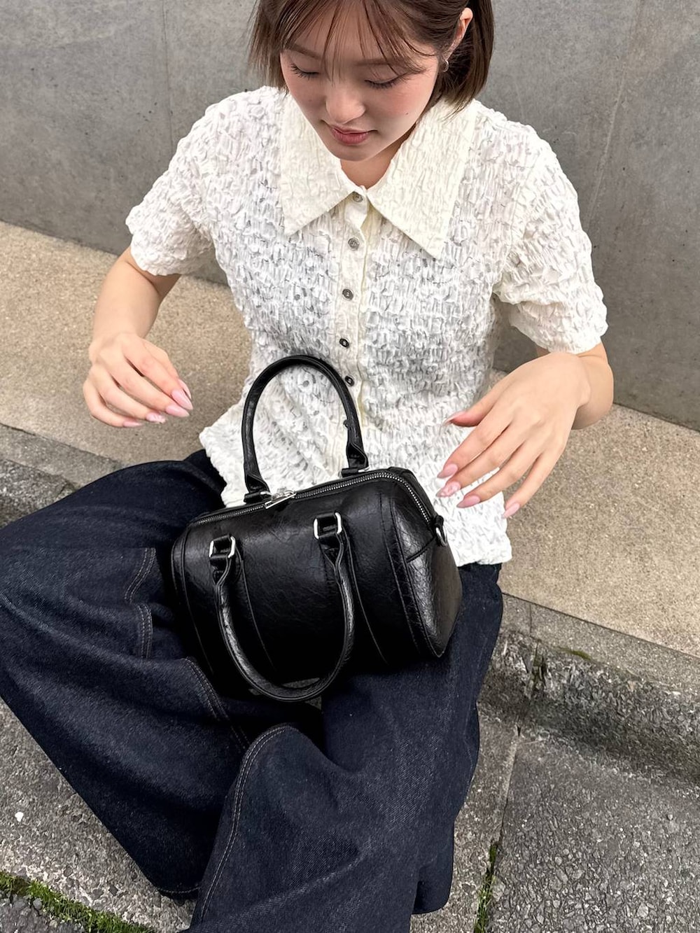 ブルー系のデニムパンツ、ブラック系のボストンバッグ、その他のサンダルを着用したレディースの春コーディネートの3枚目の写真