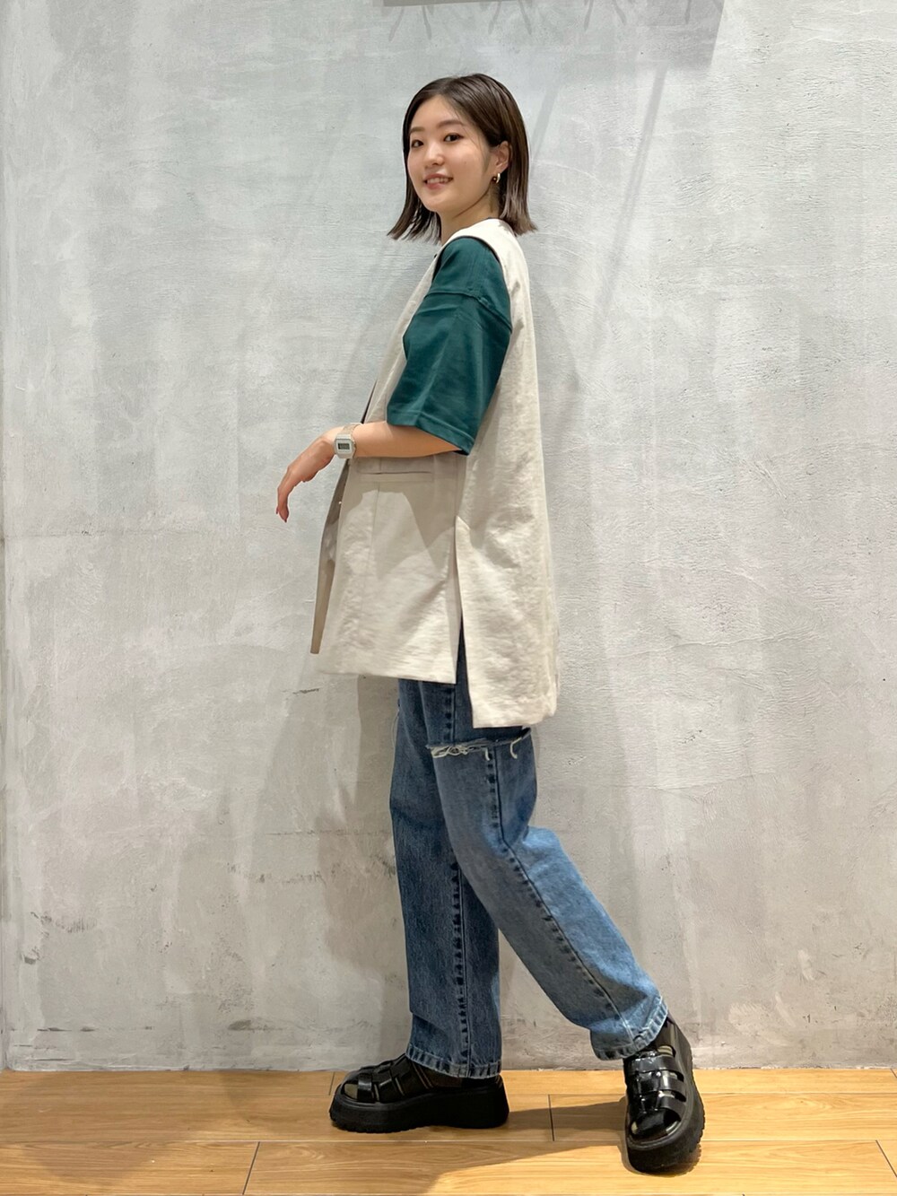 ブルー系のデニムパンツ、ブラック系のサンダル、ベージュ系のその他アウターを着用したレディースの夏コーディネートの2枚目の写真