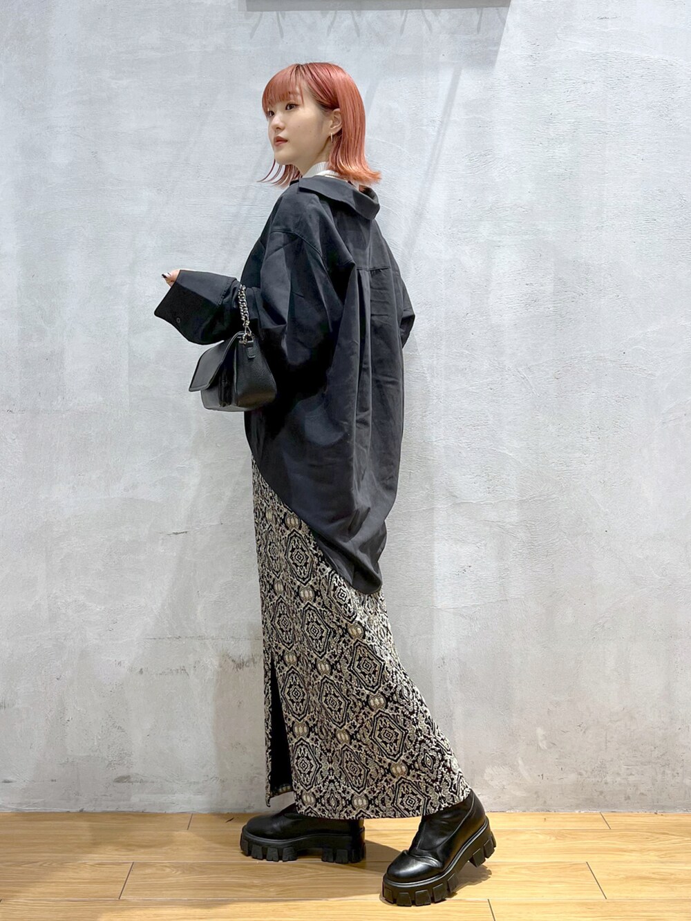 ブラック系のスカート、ブラック系のショルダーバッグ、ブラック系のシャツ/ブラウスを着用したレディースの秋コーディネートの2枚目の写真