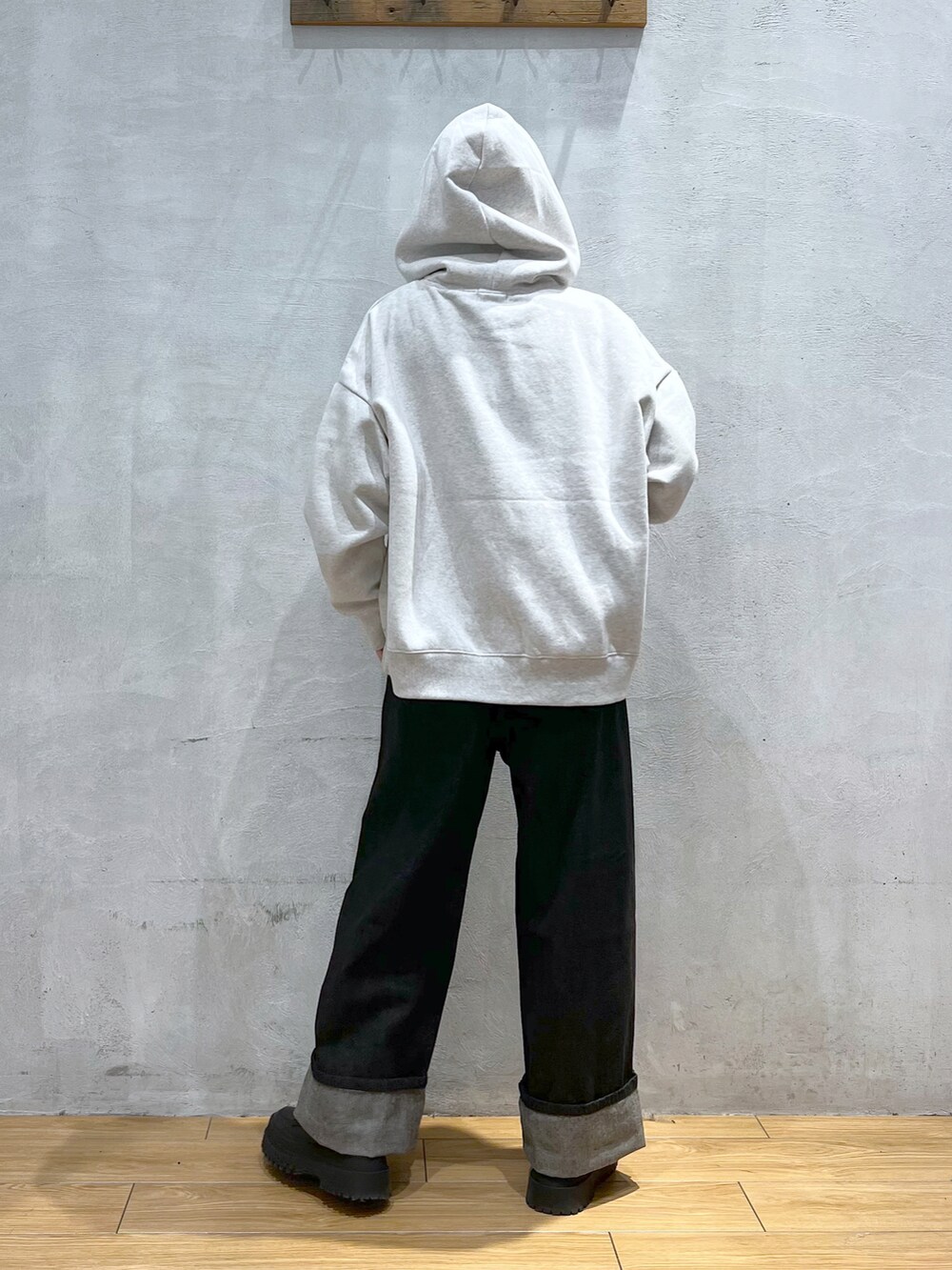 ブラック系のデニムパンツ、グレー系のパーカー、ブラック系のブーツを着用したレディースの冬コーディネートの3枚目の写真